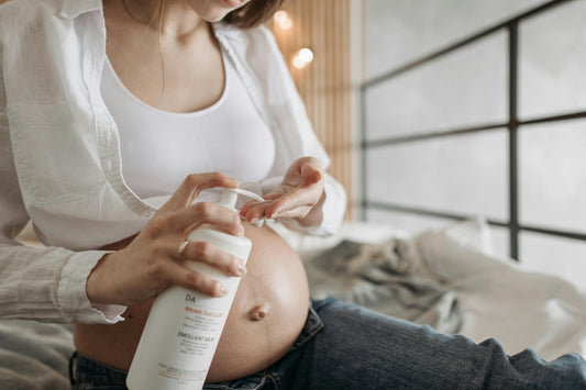 Mujer sentada echándose crema en la barriga