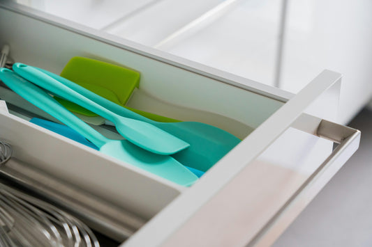 spátulas de plástico de cocina de color azul en un cajón