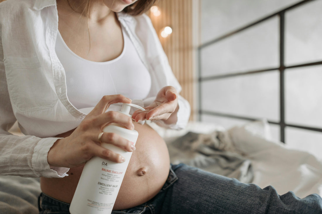 Mujer sentada echándose crema en la barriga